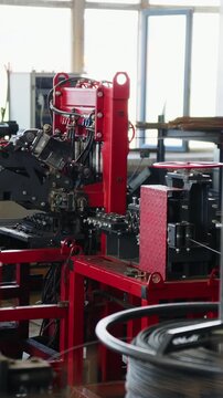 Mesh welding machine with steel wire coils in the foreground at a wire mesh factory