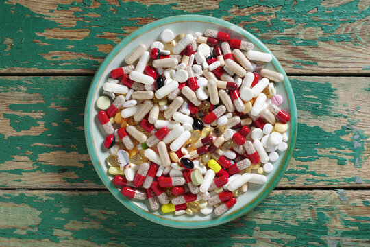 Assorted pills on wooden background