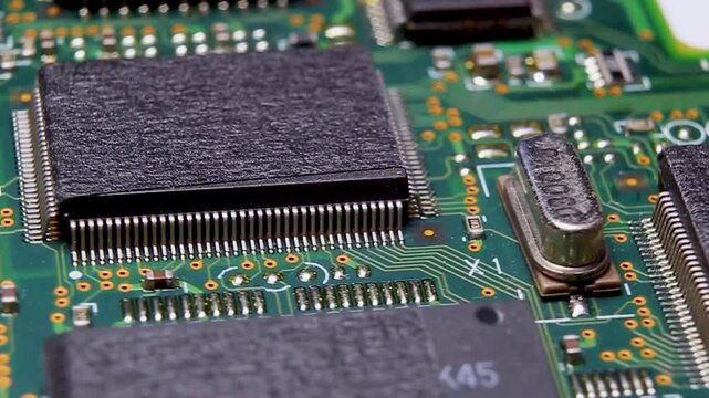 View of a part of an electronic printed circuit board with SMD components and a large microcircuit, video macro shooting
