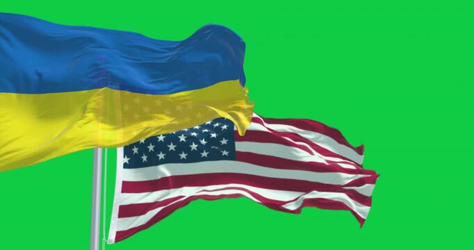 Ukraine and US national flags waving in the wind isolated on green background