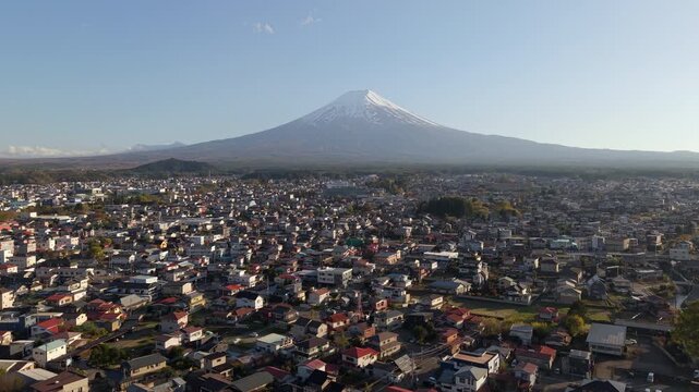 Aerial jib shot of Mount Fuji towering over Fujiyoshida city, Yamanashi, Japan.