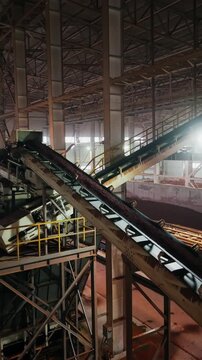 Inclined clay conveyors and an open clay storage bunker in a large brick factory hall