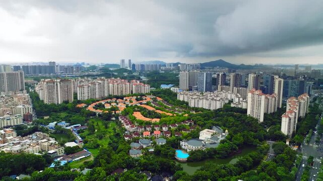 Residential roofs and greenery beneath dark clouds in Guangzhou