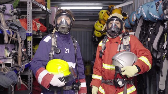 Firefighters equipped with breathing apparatus posing looking to camera