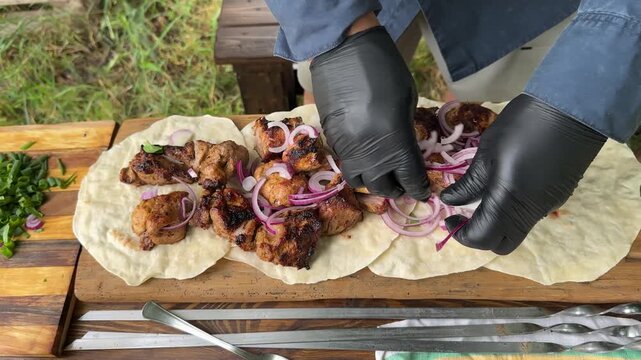 Pieces of hot, juicy shashlik served on lavash are sprinkled with sliced ​​red onion. High quality 4k footage