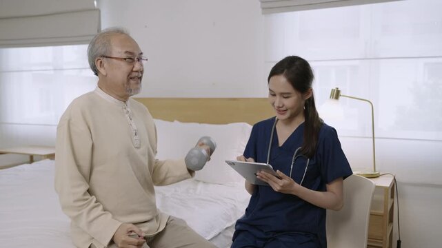 Professional Asian woman nurse physiotherapist using a dumbbell for workout exercise for physical recovery of muscles and bones of a senior man patient in hospital bed. Healthcare and medical concept.