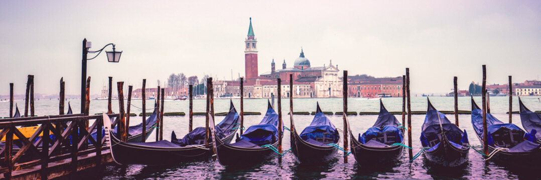 Gondolas in Venice with Abbey of San Giorgio Maggiore in the background. Ferry Gondola Pier. Venice, Italy