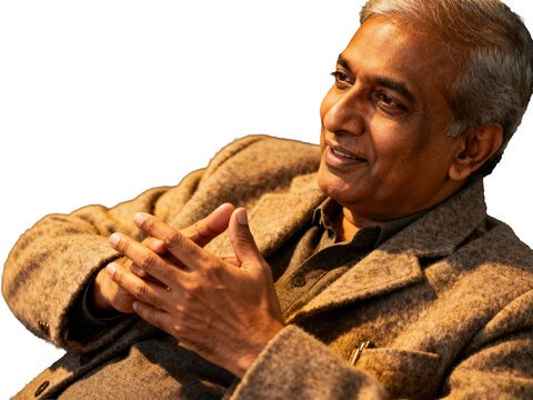 Distinguished Indian professional, silver hair, warm smile, brown textured blazer, hands clasped, isolated on transparent background
