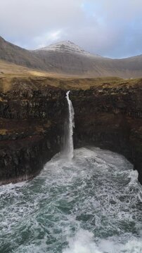 フェロー諸島ヴァーガル島ガーサダルル、断崖から大西洋へ落ちるムーラフォッスルの滝を空撮（M&uacute;lafossur Waterfall, G&aacute;sadalur, Faroe Islands Aerial）