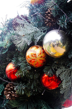 Decorated Evergreen Branches with Festive Red and Gold Ornaments and Pine Cones