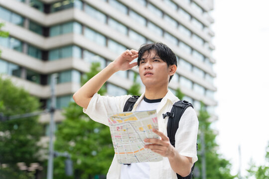 地図を見て旅行するアジア人観光客。インバウンド、迷う、ガイドマップ、日本、東京、ツアー、外国人、案内