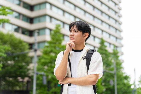 考えるアジア人男性。観光客、インバウンド、旅行、東南アジア、観光、日本、ツアー、留学生、外国人、学生