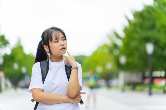 A thinking Asian woman. Tourists, inbound tourism, travel, Southeast Asia, sightseeing, Japan, tours, international students, foreigners, students