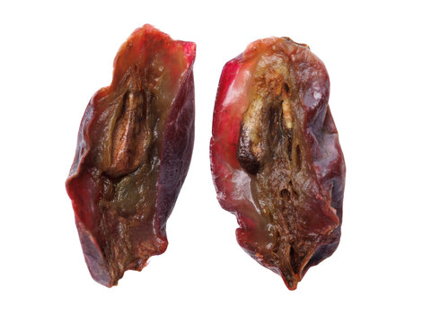 Ripe berry halves show dark red flesh and shriveled skin. Texture reveals dried, wrinkled surface with natural color variations. Isolated on white background for clear product display.