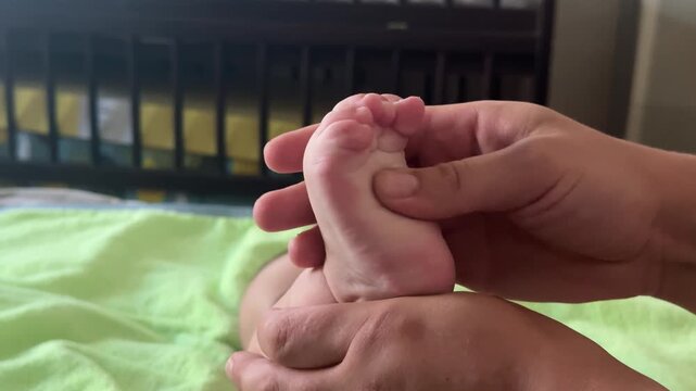 Close-up of a hand kneading and massaging an infant's heel. High quality 4k footage