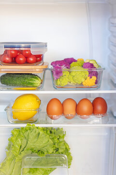 Fresh vegetables in glass containers are on the shelves in the refrigerator. Home order concept