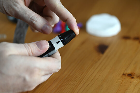 A person checks their blood sugar and pricks their finger with a lancet