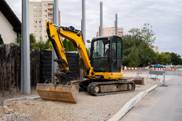 A yellow excavator parked at a construction site © Олеся Матвеева