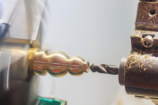Hole making process on a brass material port by a drill tool on a lathe machine