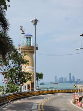 Scenic view of Cape Bali Hai Lighthouse on the coastal curved road with sea and Pattaya skyline view, Chonburi, Thailand