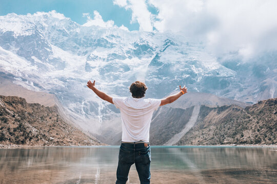 young man with arms raised in nature