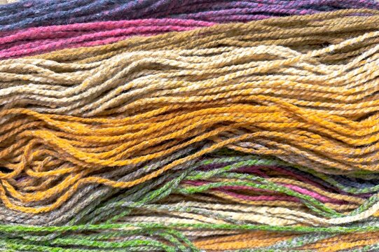 Detailed texture of natural earth-toned hand-dyed wool yarn strands for traditional weaving and knitting