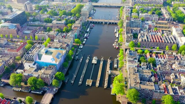 Amsterdam, Netherlands. Flying over the city rooftops. Amstel River, Amstel Gateways. Drone footage
