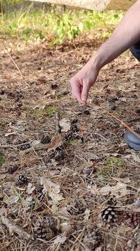 Hands tie a guyline cord around a carbon stake in the ground.