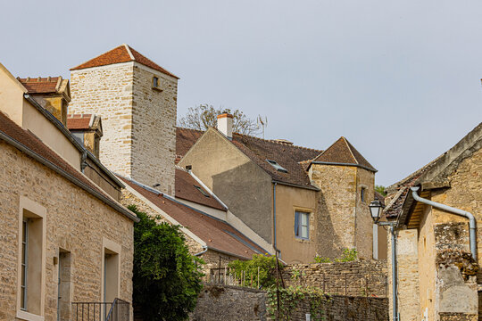 Stone houses and tiled rooftops around a historic village tower, Yonne, Montr&eacute;al, France