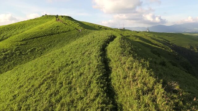 阿蘇の草原に伸びる尾根道を空撮、夏の緑の丘と登山道（Aso Grassland Ridge Trail Aerial, Kumamoto Japan）