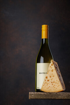 White wine bottle with cheese on rustic table