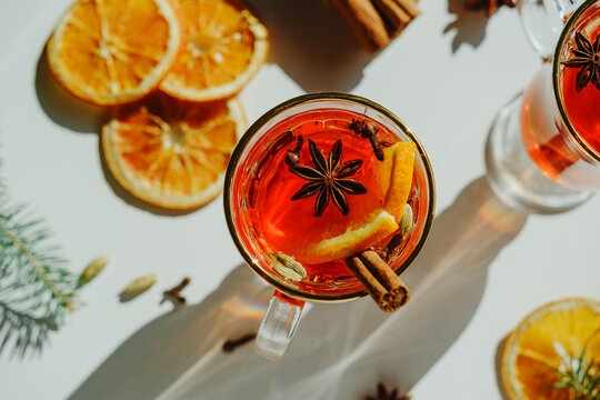 Red mulled wine with orange slices and spices on a white background