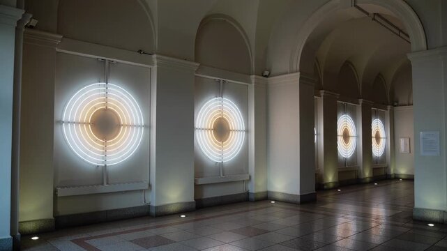 Lighting LED ring lights after point appearing in arched corridor, creating rhythmic reflections