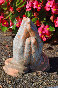 praying hands on a grave