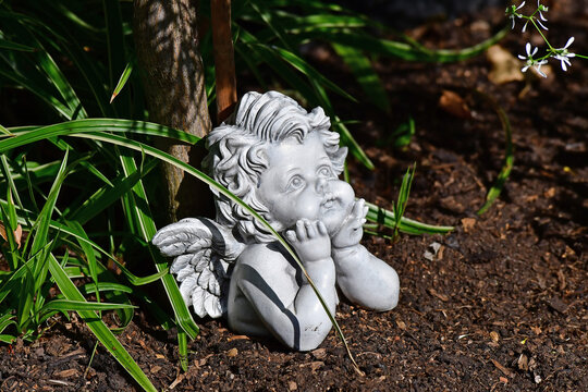 sweet angel figure on a grave in autumn with fallen leaves