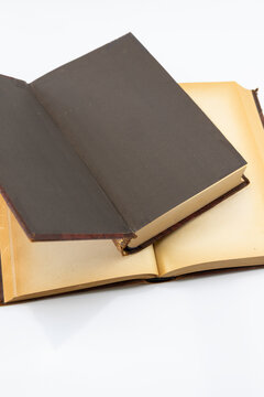 Vertical open antique book with yellowed pages on white background.