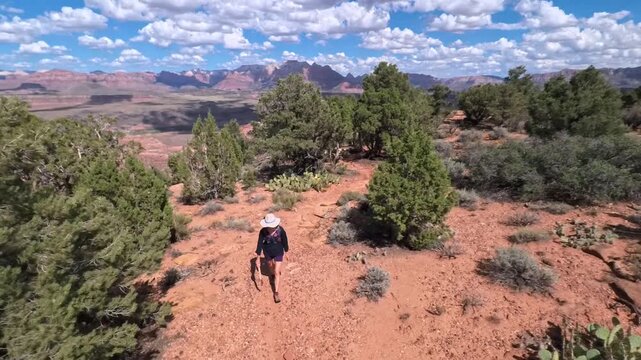 Senior woman enjoys a scenic hike along the Gander Trail on Gooseberry Mesa, surrounded by breathtaking views of Zion National Park.