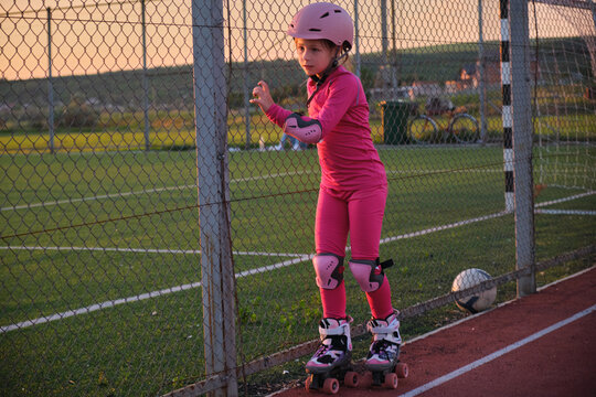 Young girl learn to roller skate outdoor park sport active healthy child