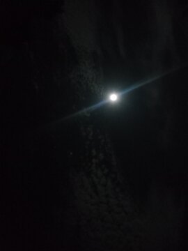 Full moon shining bright in the dark night sky with stars

