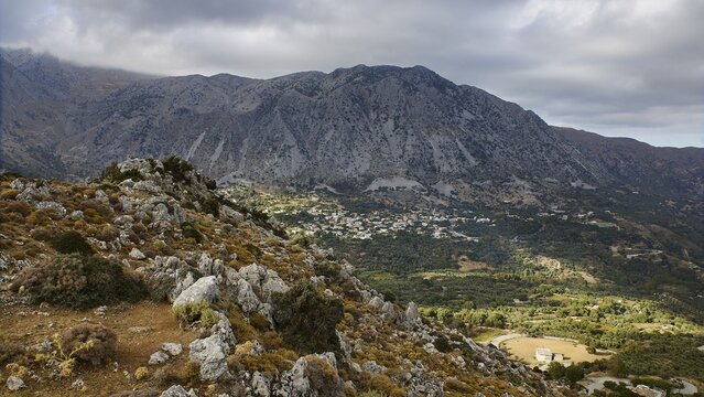 View of a quiet valley with scattered settlements, surrounded by the majesty of the mountains under a cloudy sky, Kallikratis, Kallikratis Gorge, Sfakia, West Crete, Crete, Greek Islands, Greece