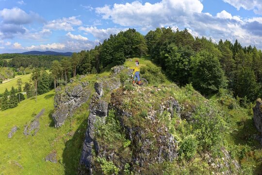 Aerial view of the rock above Oberailsfeld with cyclist figure, called Claudius, Oberailsfeld, Franconian church village, district of Ahorntal, Ailsbachtal, Franconian, Franconian Alb, Upper Franconia, Franconia, Bavaria, Germany