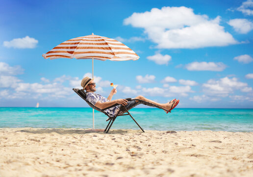 Man relaxing in a lounge chair with a cocktail