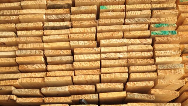 Stacks rectangular sawn timber sheets are neatly stacked in a warehouse : Large quantities raw timber have neatly stacked ready serve raw material production wooden pallets and industrial packaging.