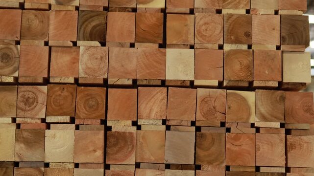 Stacks rectangular sawn timber arranged in a warehouse : Large quantities of raw timber have been neatly stacked ready serve as raw material for the production wooden pallets and industrial packaging.