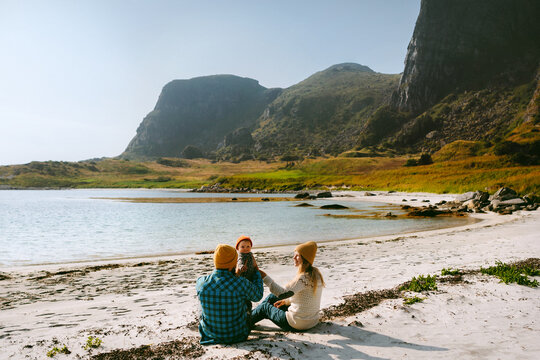 Parents and baby infant having fun together on beach travel in Norway family adventure, mother father and child explore Helgeland islands happy childhood bonding love recreation and holidays outdoor