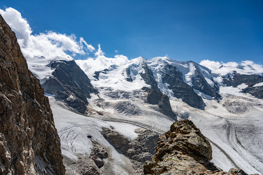 Majestic Piz Palu rises amid the stunning Swiss Alps, showcasing its glaciers and rocky peaks. The clear blue sky enhances the beauty of this remote alpine landscape, attracting nature enthusiasts.