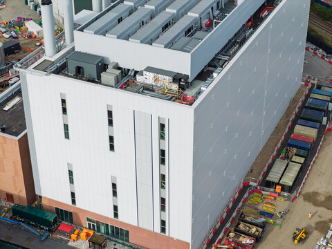 Aerial view of a modern data center building with industrial rooftop equipment and construction site elements in the United Kingdom.