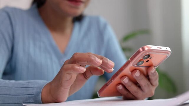 Female designer operating portable touchscreen device with digital stylus pen at work table reviewing creative project graphics in bright contemporary studio workplace room