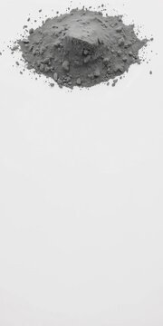 Gray powder pile with textured surface sits atop a smooth white background, background, experiment