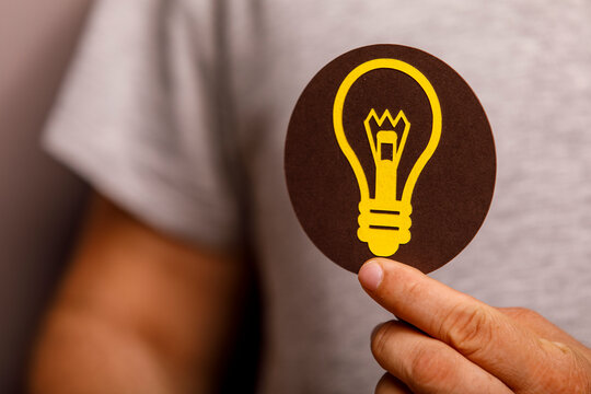 A hand holds a lightbulb icon, representing creativity, innovation, and bright ideas.
